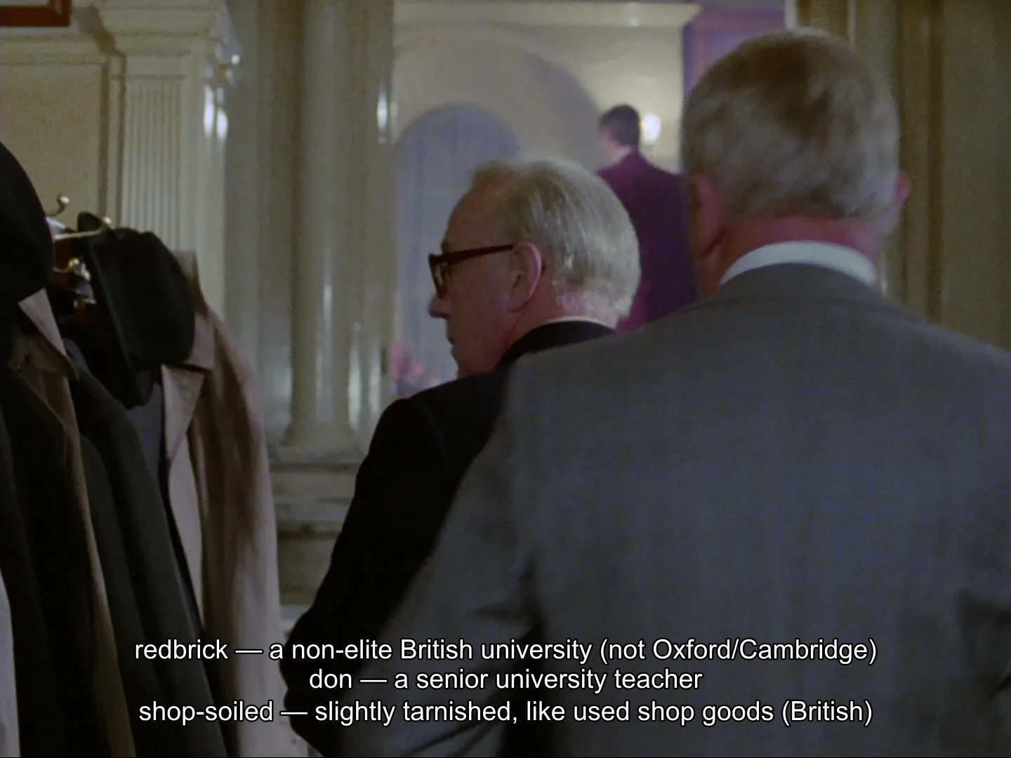 Three Explainer definitions stacked along the bottom of a scene from Tinker, Tailor, Soldier, Spy (1979): "redbrick — a non-elite British university (not Oxford/Cambridge)", "don — a senior university teacher", and "shop-soiled — slightly tarnished, like used shop goods (British)"